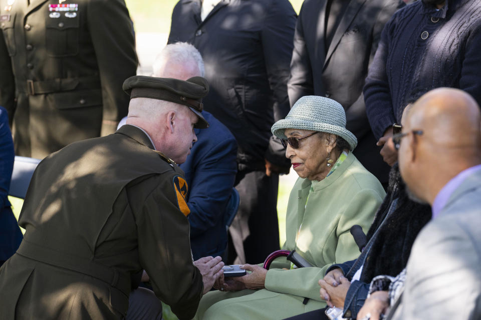 First Army's Command Sgt. Maj. Chris Prosser, left, presents Joann Woodson with her husband's Bronze Star during a posthumous medal ceremony at Arlington National Cemetery on Tuesday, Oct. 11, 2023 in Arlington, Va. During the D-Day invasion, the landing craft Cpl. Waverly B. Woodson Jr was in took heavy fire and he was wounded before even getting to the beach, but for the next 30 hours he treated 200 wounded men while under intense small arms and artillery fire before collapsing from his injuries and blood loss, according to accounts of his service. (AP Photo/Kevin Wolf)