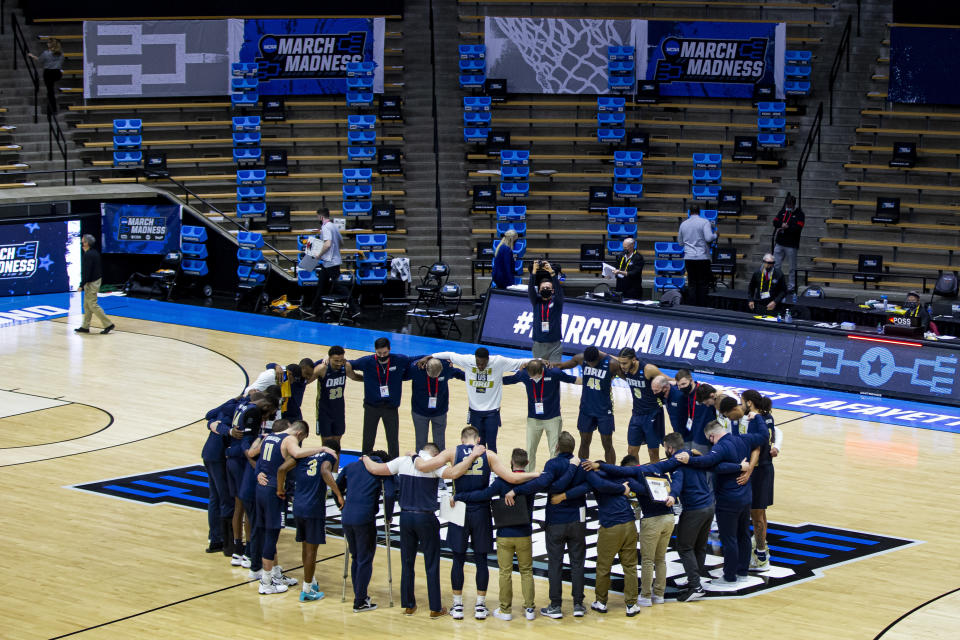 Oral Roberts players and coaches form a prayer circle on the court following their win over Ohio State in a first-round game in the NCAA men's college basketball tournament, Friday, March 19, 2021, at Mackey Arena in West Lafayette, Ind. (AP Photo/Robert Franklin)