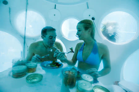 Belgians Florence Lutje Spelberg and Nicolas Mouchart have dinner while sitting inside "The Pearl", a spheric dining room placed 5 metres underwater in the NEMO33 diving center, one of the world's deepest pools (33 metre/36 yards) built to train professional divers, in Brussels, Belgium January 30, 2017. Picture taken January 30, 2017 REUTERS/Yves Herman