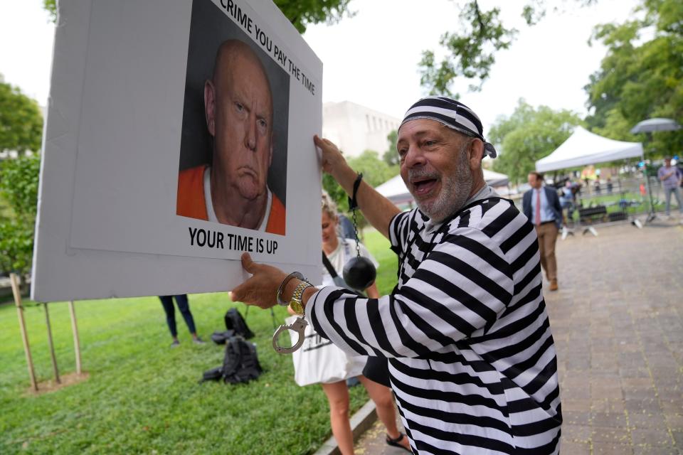 Domenic Santana, 61, of Miami, holds a sign with a fake image of Donald Trump outside the E. Barrett Prettyman United States Courthouse on Aug 3, 2023. Former President Donald Trump is set to be arraigned on four charges related to the 2020 election. Federal prosecutors are accusing Trump of undermining American democracy by organizing a wide-ranging conspiracy to steal the 2020 election that prosecutors allege fueled a brazen and historic insurrection at the U.S. Capitol.