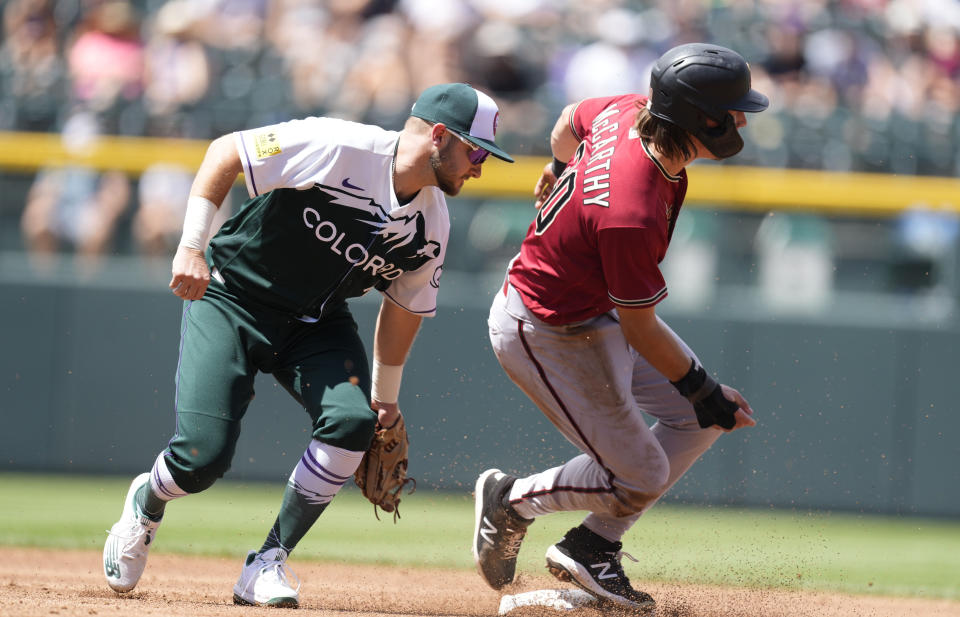 Arizona Diamondbacks' Jake McCarthy, right, steals second base as Colorado Rockies shortstop Garrett Hampson fields a throw in the second inning of a baseball game Sunday, Aug. 14, 2022, in Denver. (AP Photo/David Zalubowski)