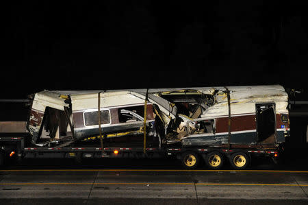 A damaged Amtrak passenger train car sits on a flatbed truck after being lifted from the tracks at the site of the derailment of Amtrak train 501 in Dupont, Washington, U.S., December 19, 2017. REUTERS/Thomas James