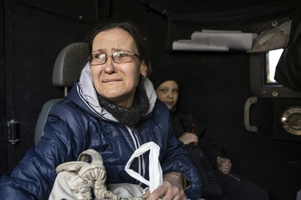Olga Shulga and her son Myroslav ride in a van during an evacuation by Ukrainian police, in Avdiivka, Ukraine, Tuesday, March 7, 2023. For months, authorities have been urging civilians in areas near the fighting in eastern Ukraine to evacuate to safer parts of the country. But while many have heeded the call, others -– including families with children -– have steadfastly refused.(AP Photo/Evgeniy Maloletka)