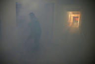 A worker fogs the corridor of a public housing estate in the vicinity where a locally transmitted Zika virus case was discovered, in Singapore August 29, 2016. REUTERS/Edgar Su