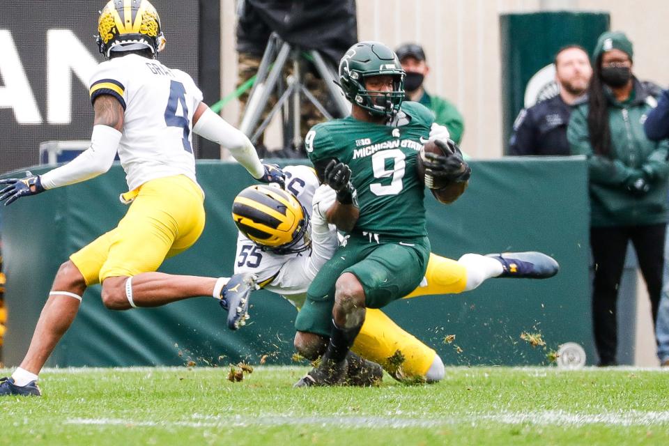 Michigan linebacker David Ojabo tackles Michigan State running back Kenneth Walker III during the first half at Spartan Stadium in East Lansing on Saturday, Oct. 30, 2021.