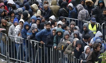 Migrants queue in the compound outside the Berlin Office of Health and Social Affairs (LAGESO) as they wait to register in Berlin, Germany, October 7, 2015. REUTERS/Fabrizio Bensch