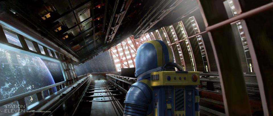 dr. eleven in station eleven in concept art, a spaceman facing away from the camera wearing a yellow and blue spacesuit. he's gazing out of a wide window from a spaceship towards the horizon of the earth. the spaceship is reminiscent of a tall building turned on its side, inspired by the thompson center of chicago