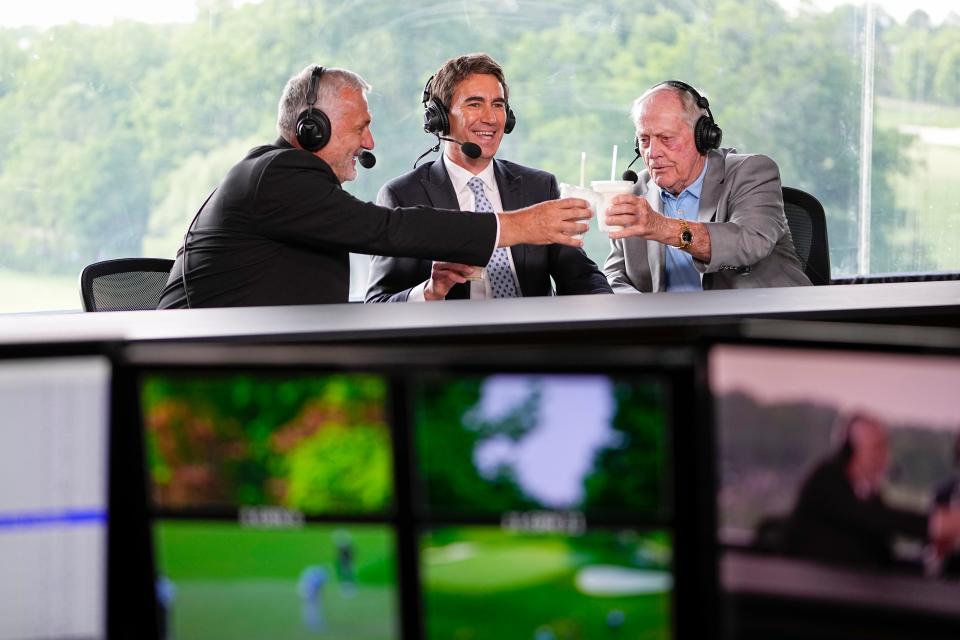 Jack Nicklaus gives a milkshake cheers to Terry Gannon, middle, and Frank Nobilo, left, in the television broadcast booth above the 18th green during the second round of the Memorial Tournament at Muirfield Village Golf Club.