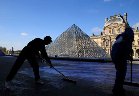 French artist JR works in the courtyard of the Louvre Museum near the glass pyramid designed by Ieoh Ming Pei as the Louvre Museum celebrates the 30th anniversary of its glass pyramid in Paris, France, March 26, 2019. REUTERS/GonzaloÊFuentes