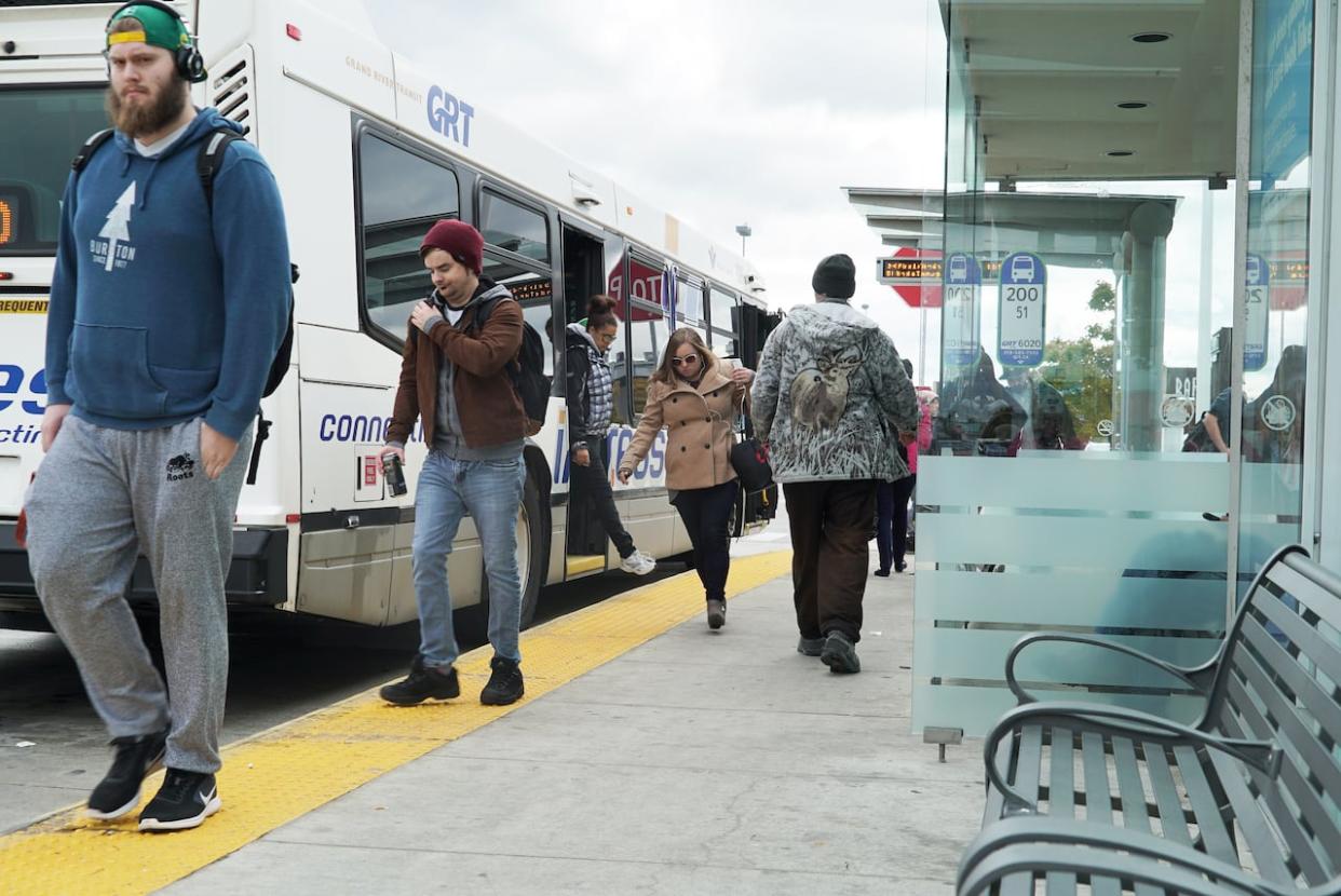 Transit passengers get off a Grand River Transit bus at a stop at the Cambridge Centre. (Kate Bueckert/CBC - image credit)