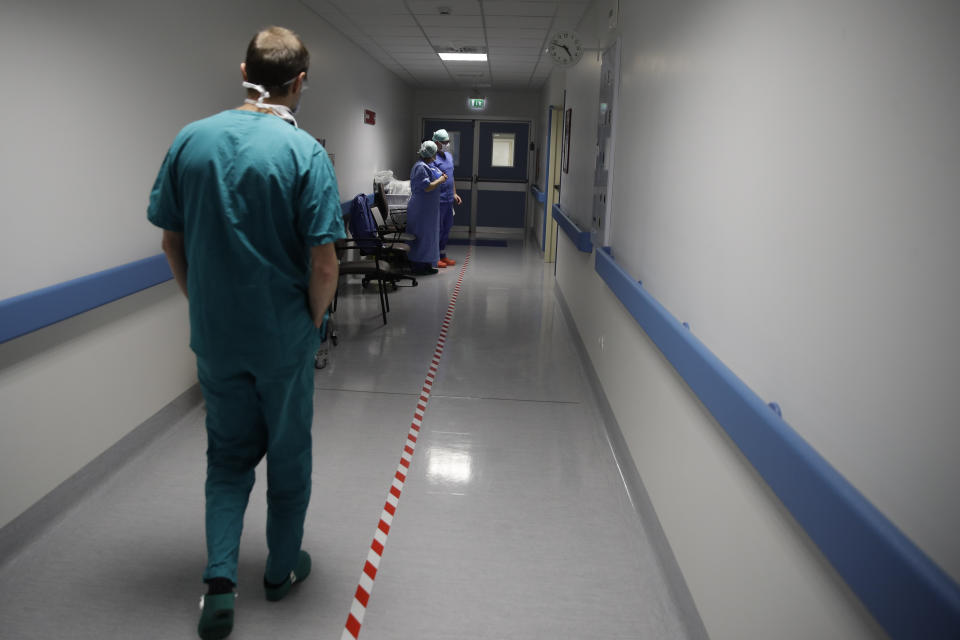 In this March 16, 2020, photo, Sergio Cattaneo, head of the anesthesia and resuscitation unit of the Brescia Spedali Civili hospital, walks to the ICU room, in Brescia, Italy. Three weeks into Italy’s coronavirus crisis, Cattaneo has seen an unused ward outfitted into an intensive care unit in six days, a hospital laundry room converted into a giant stretcher-filled waiting room and a tented field hospital erected outside to test possible new virus patients. (AP Photo/Luca Bruno)