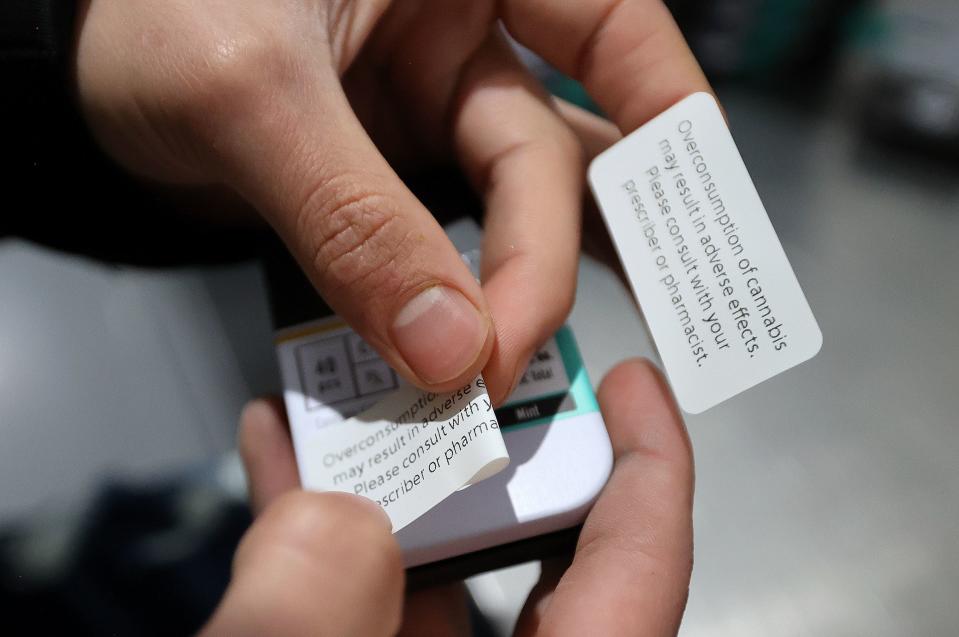 Gabe Flores, Dragonfly quality control agent, puts stickers on cannabis packaging at the Dragonfly processing plant in South Salt Lake on Friday, March 24, 2023. Stickers are needed to adhere to rapidly changing rules and regulations for cannabis packaging. | Kristin Murphy, Deseret News