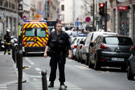 A French policeman secures the street as a man has taken two people hostage at a business in Paris, France, June 12, 2018. REUTERS/Benoit Tessier