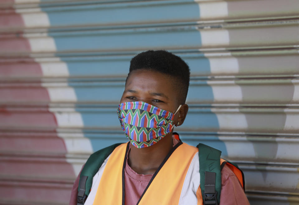 In this photo taken Tuesday, May 19, 2020, a worker wears a face mask to protect against coranavirus, at a mall in Khayelitsha in Cape Town South Africa. With dramatically increased community transmission, Cape Town has become the center of the COVID-19 outbreak in South Africa and the entire continent. (AP Photo/Nardus Engelbrecht)