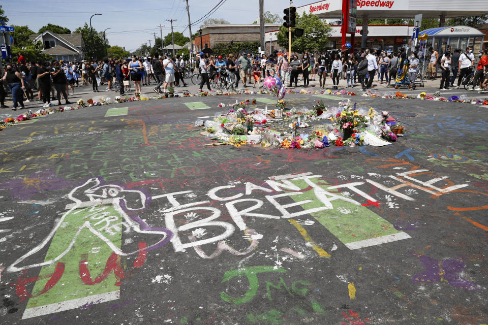 FILE - In this May 31, 2020, file photo, mourners gather to place flowers at a makeshift memorial for George Floyd at the corner of Chicago Avenue and East 38th Street in Minneapolis. For most police officers going on trial, the argument that they made a split-second decision in a life-or-death situation often carries significant weight for a jury. It's a reason officers are so rarely convicted. But it's an argument that's almost certainly not available to Derek Chauvin, the fired Minneapolis police officer who goes on trial Monday, March 29, 2021, in Floyd's death. (AP Photo/John Minchillo, File)