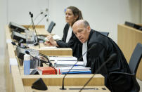 Sabine ten Doesschate, rear, and Boudewijn van Eijck, lawyers for one of the four suspects, Russian Oleg Pulatov, are seen as the trial resumed at the high security court building at Schiphol Airport, near Amsterdam, Monday, June 8, 2020, for three Russians and a Ukrainian charged with crimes including murder for their alleged roles in the shooting down of Malaysia Airlines Flight MH17 over eastern Ukraine nearly six years ago. (AP Photo/Robin van Lonkhuijsen, POOL)