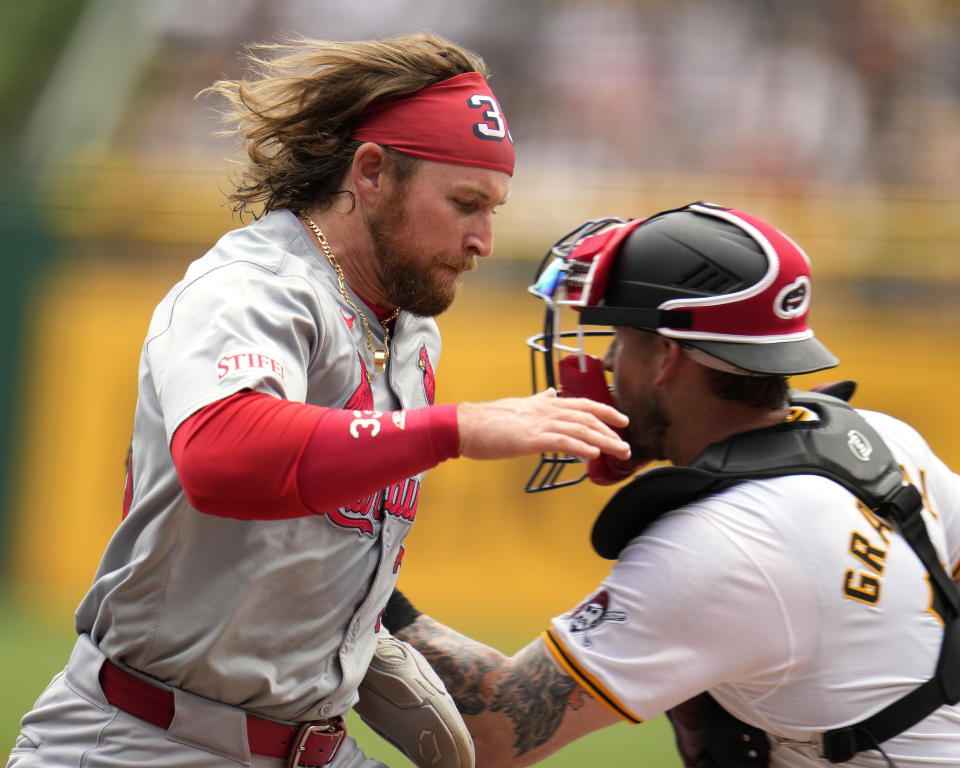 St. Louis Cardinals' Brendan Donovan, left, scores past Pittsburgh Pirates catcher Yasmani Grandal on a double by Dylan Carlson off Pirates starting pitcher Martín Pérez during the first inning of a baseball game in Pittsburgh, Thursday, July 4, 2024. (AP Photo/Gene J. Puskar)