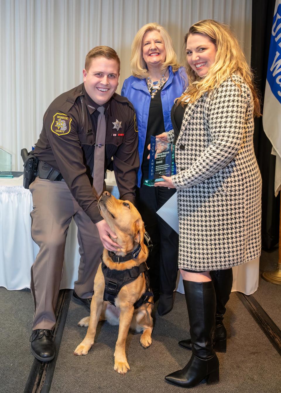 Pictured are Monroe County Sheriff's Deputy James Liedel, left, with Animal Rescue Hero Stretch, Susan Vanisacker and Ashleigh Glass.