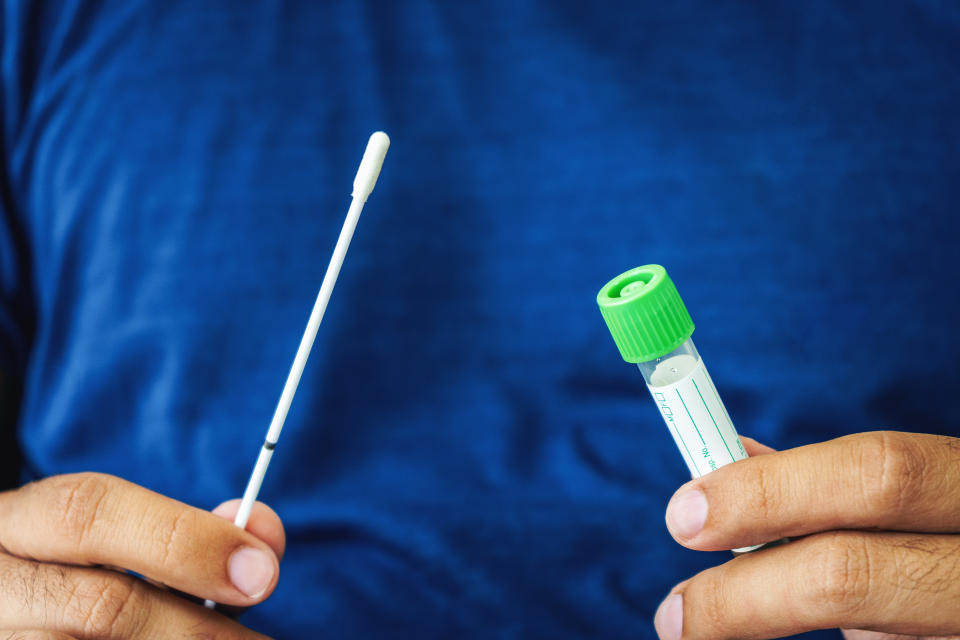 Young man  holds a swab and medical tube for the coronavirus / covid19 home test