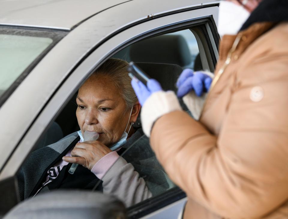 Martina Garcia, of Des Moines, takes a saliva Covid-19 test at a Polk County mobile testing site in the parking lot of River Place located at 2309 Euclid Ave in Des Moines. 