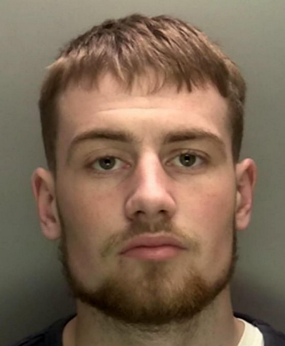 A teenage yob is facing jail after shocking footage caught him ramming a police officer off his motorbike in a stolen car. Callum Fellows, 18, was behind the wheel of a dark blue Seat Leon which was being followed by PC Steve Lovering. When the car stopped at traffic lights the officer drove up to the driver's door but Fellows suddenly reversed before steering straight into PC Lovering's BMW bike. CCTV and the officer’s body-cam captured the shocking moment when PC Lovering was sent sprawling onto Ashes Road in Oldbury, West Mids. The officer is heard shouting out in pain before radioing colleagues for help as Fellows sped away.