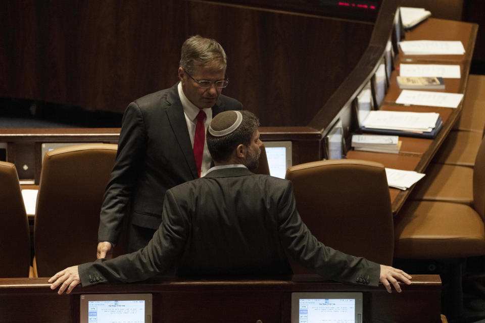 Lawmaker Bezalel Smotrich, foreground, leader of the Religious Zionist Party, talks with a colleague during a session of the Knesset, Israel's parliament, in Jerusalem, Monday, June 6, 2022. (AP Photo/ Maya Alleruzzo)