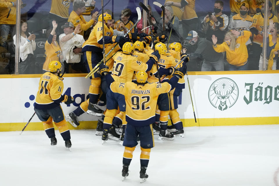 Nashville Predators players celebrate after Matt Duchene scored the winning goal against the Carolina Hurricanes during the second overtime in Game 3 of an NHL hockey Stanley Cup first-round playoff series Friday, May 21, 2021, in Nashville, Tenn. The Predators won 5-4. (AP Photo/Mark Humphrey)
