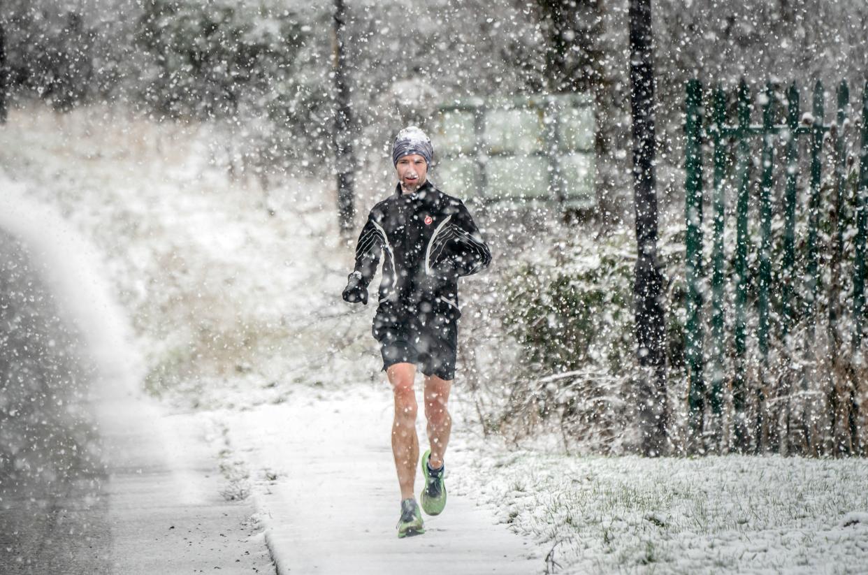 Jogger runs through snow in Knaresborough, in North Yorkshire (PA)