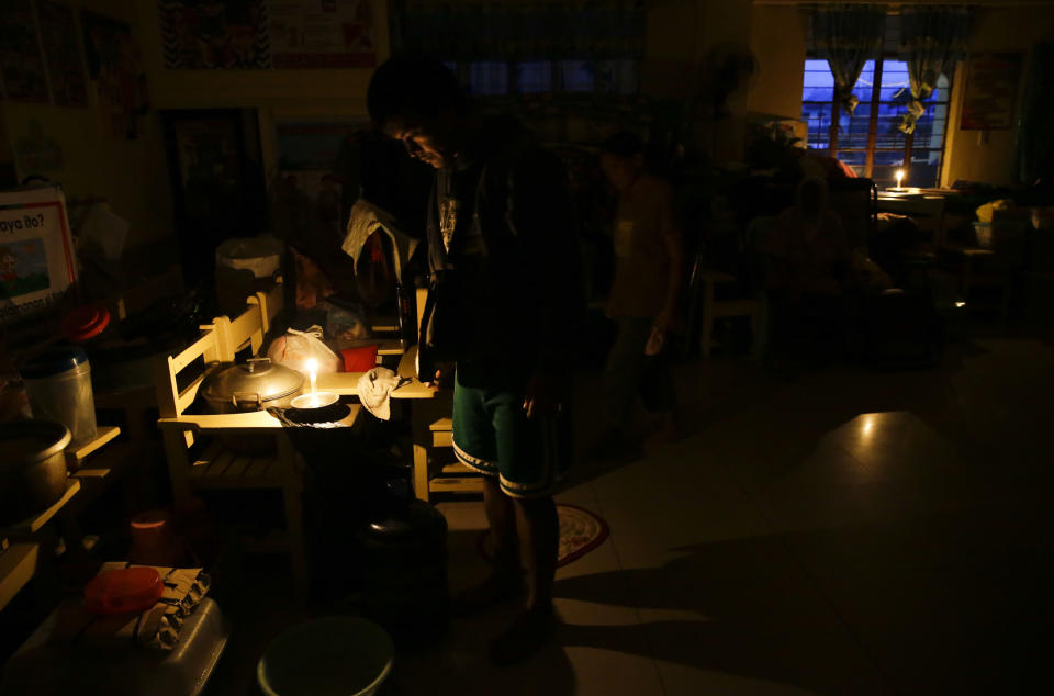 Evacuees use candles inside a temporary evacuation center as electricity was shut-off following the onslaught of Typhoon Mangkhut in Tuguegarao city in Cagayan province, northeastern Philippines, Saturday, Sept. 15, 2018. The typhoon slammed into the Philippines northeastern coast early Saturday, it's ferocious winds and blinding rain ripping off tin roof sheets and knocking out power, and plowed through the agricultural region at the start of the onslaught. (AP Photo/Aaron Favila)
