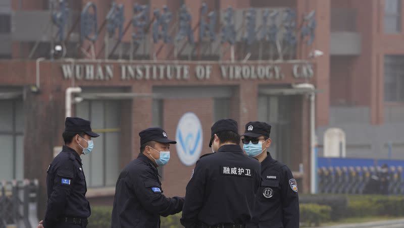 Security personnel gather near the entrance of the Wuhan Institute of Virology during a visit by the World Health Organization team in Wuhan in China’s Hubei province on Wednesday, Feb. 3, 2021.