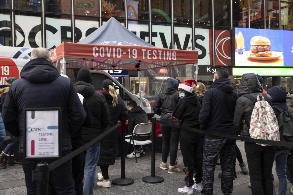 People wait in line to get tested for COVID-19 at a mobile testing site in Times Square on Friday, Dec. 17, 2021, in New York. New York City had been mostly spared the worst of the big surge in COVID-19 cases that has taken place across the northeastern and midwestern U.S. since Thanksgiving, but the situation has been changing rapidly in recent days. (AP Photo/Yuki Iwamura)