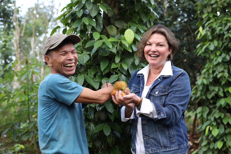 A land mine survivor hands Heidi Kuhn a cluster of chôm chôm, a fruit native to Vietnam.