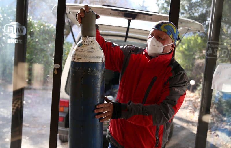 Miralem Sabic carries oxygen bottles from his private van to an improvised coronavirus disease (COVID-19) hospital in Konjic, Bosnia and Herzegovina