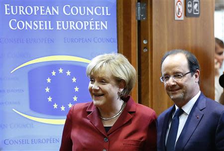 Germany's Chancellor Angela Merkel (L) and France's President Francois Hollande arrive at a European Union leaders summit in Brussels October 24, 2013. REUTERS/Yves Herman