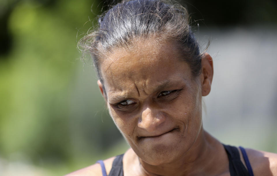 In this Wednesday, July 24, 2019, photo Ivette Naida talks with social workers from the IDEA Exchange, in Miami. Naida is participating in the University of Miami-sponsored program, which provides HIV-infected homeless people with secure medication lockers or delivers small quantities of medicine to them directly. Naida, who was diagnosed with HIV more than a decade ago, lives underneath a Miami highway overpass and has no safe place to keep her belongings. (AP Photo/Lynne Sladky)