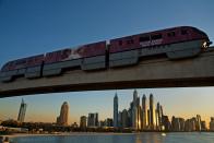 FILE - A monorail on the Palm Jumeirah passes on a track above the skyline of the Dubai Marina in Dubai, United Arab Emirates, on Dec. 21, 2019. The FIFA World Cup may be bringing as many as 1.2 million fans to Qatar, but the nearby flashy emirate of Dubai is also looking to cash in on the major sports tournament taking place just a short flight away. (AP Photo/Jon Gambrell, File)