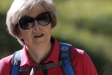 FILE PHOTO: Britain's Prime Minister Theresa May walks in a forest at the start of a summer holiday in the Alps, in Switzerland