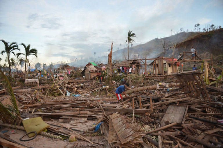 Residents pick through their destroyed homes in the aftermath of Typhoon Bopha at a village in Boston town, Davao Oriental. The death toll from the strongest typhoon to hit the Philippines this year has climbed above 700 with hundreds more missing