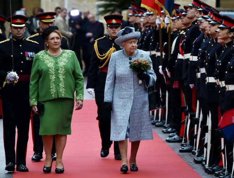 Queen Elizabeth II (C) along with the President of Malta, Marie-Louise Coleiro Preca, review a Guard of Honor after her arrival in Malta for a three-day visit, on November 26, 2015