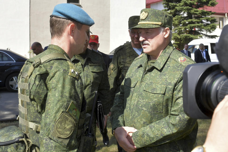 Belarusian President Alexander Lukashenko, right, speaks to an officer as he arrives to attend a meeting with military officials in Grodno, Belarus, Saturday, Aug. 22, 2020. Some hundreds of women formed a line of solidarity in the Belarusian capital of Minsk on Saturday in protest at the police crackdown on demonstrators following the disputed election that handed current president Alexander Lukashenko a sixth term in office. (Andrei Stasevich/BelTA Pool Photo via AP)