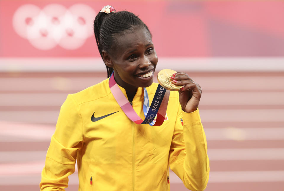 Peruth Chemutai of Uganda smiles with gold medal