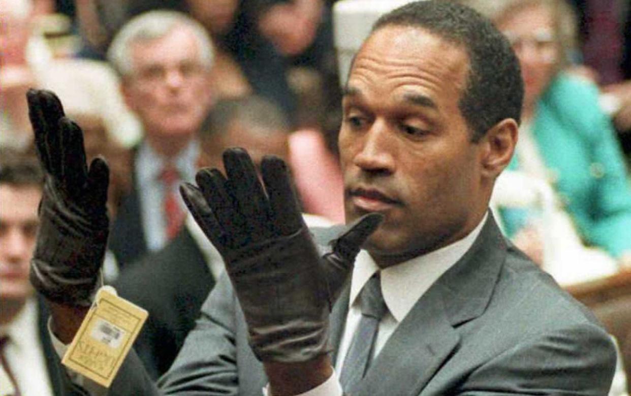 OJ Simpson trying on gloves of the type found at the murder scene during the trial