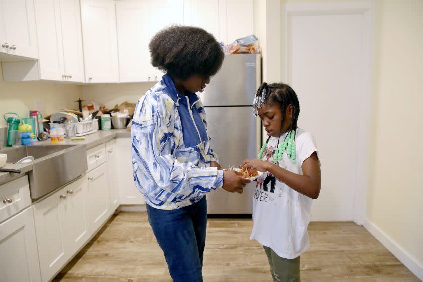 Courtney Bailey, 28, mother of five children, serves lunch to daughter NoelleMorris, 7, at their apartment