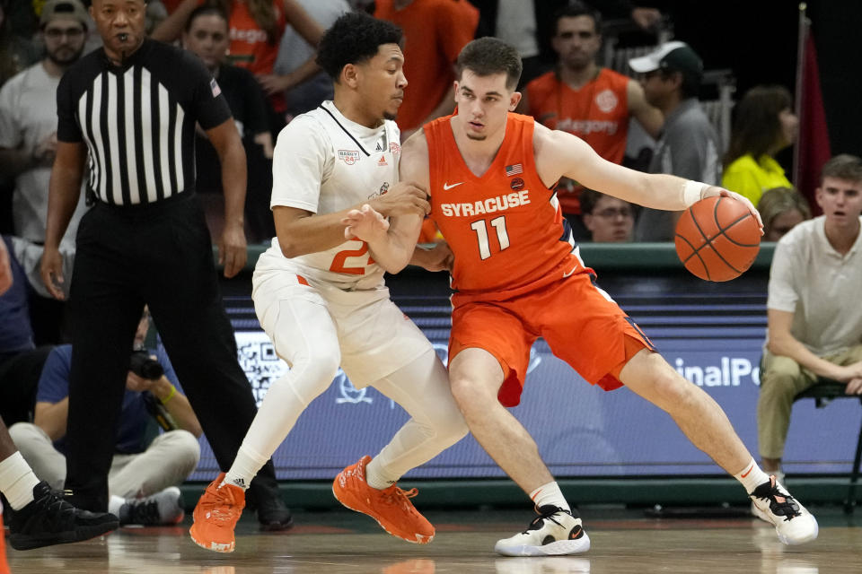 Syracuse guard Joseph Girard III (11) moves the ball as Miami guard Nijel Pack defends during the first half of an NCAA college basketball game, Monday, Jan. 16, 2023, in Coral Gables, Fla. (AP Photo/Lynne Sladky)