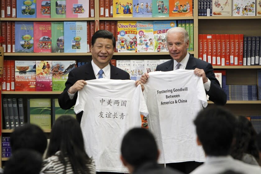 Chinese Vice President Xi Jinping and Vice President Joe Biden hold t-shirts given to them by students during their visit to the International Studies Learning Center in South Gate, Calif., Friday, Feb. 17, 2012. (AP Photo/Damian Dovarganes)