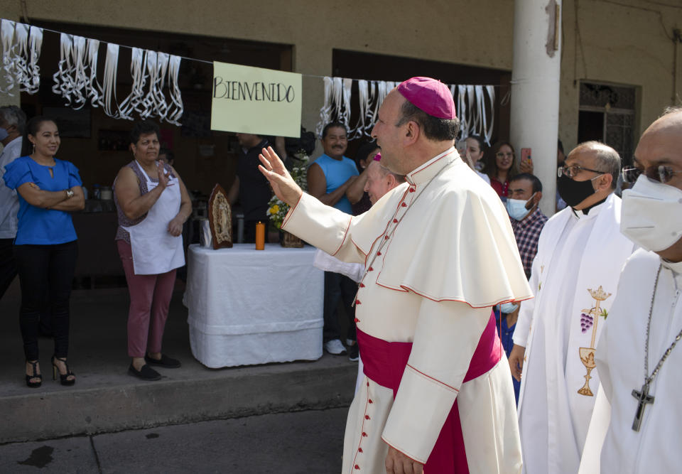 Monsignor Franco Coppola, the Vatican's diplomat to Mexico, greets people as he arrives to meet families and celebrate Mass in Aguililla, a town that has been cut off by warring cartels in Michoacan state, Mexico, Friday, April 23, 2021. State police and soldiers were sent in to restore order earlier this month, but cartels responded by parking hijacked trucks across roads to block them, as well as digging deep trenches across roadways. (AP Photo/Armando Solis)