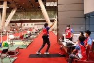 Doctor Shoji Yokobori strikes a weightlifting pose while he talks with other medical staffs at Tokyo International Forum