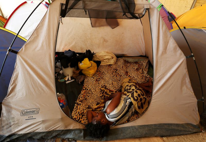 FILE PHOTO: A migrant lies in a tent at a temporary shelter during acting U.S. Secretary of Homeland Security Kevin McAleenan (not pictured) visit in the village of La Penita