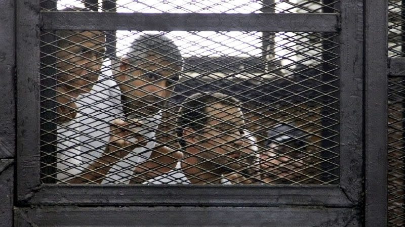 2014年6月在鐵籠中聆聽判決的三位記者（美聯社）。