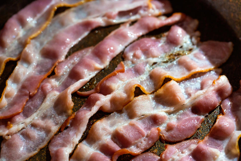 Bacon cooking in a skillet.